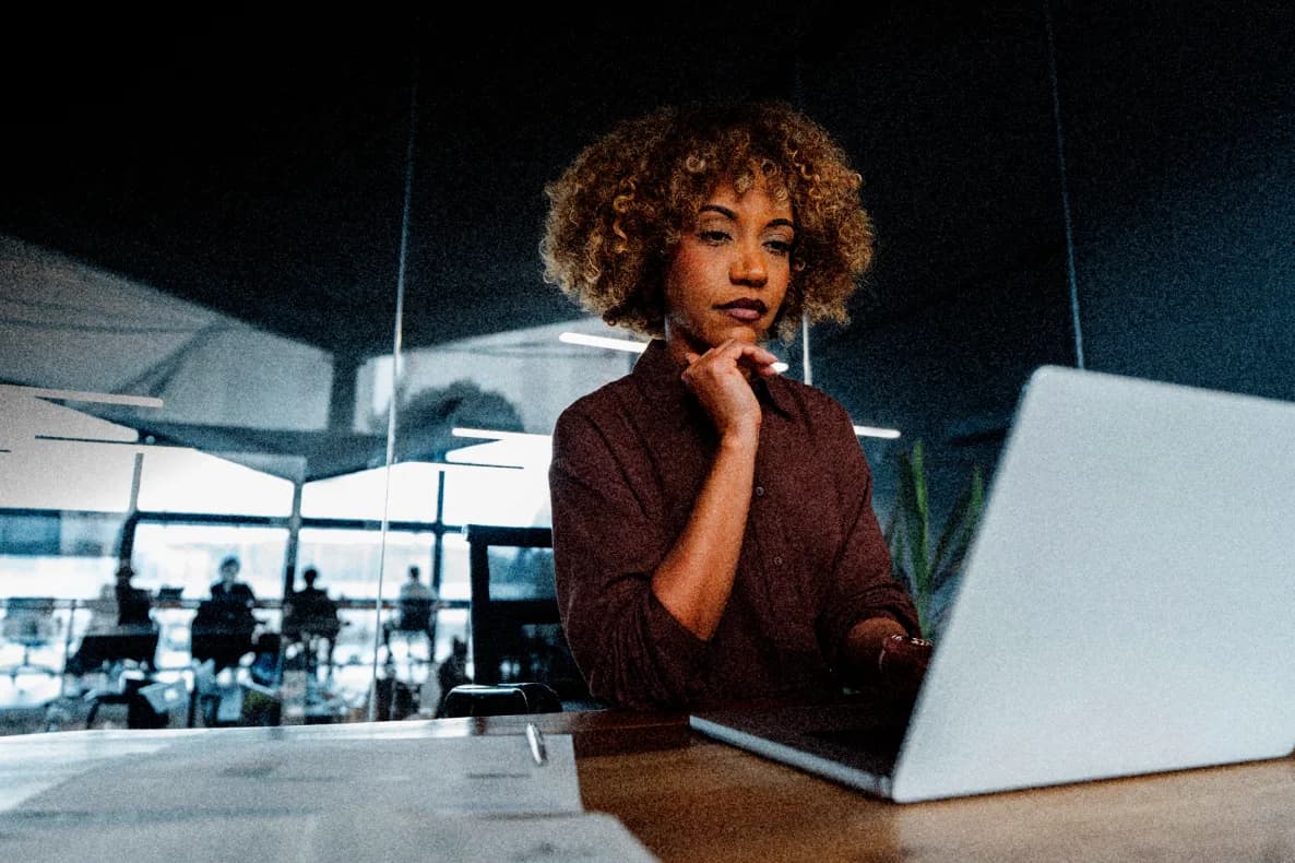 A Nymbus professional focused on work at a laptop in a modern office.
